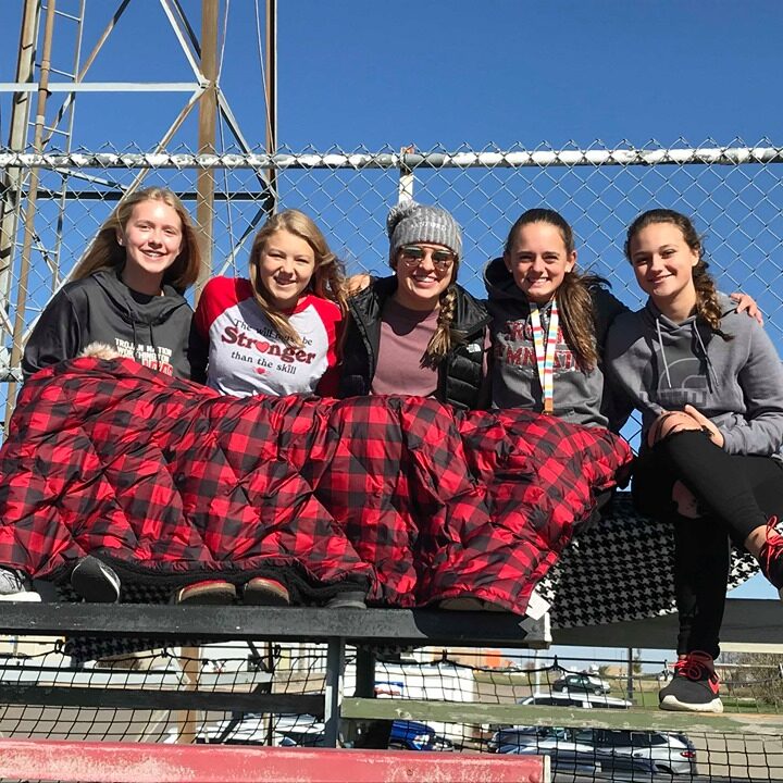 group of grils setting on steel bench