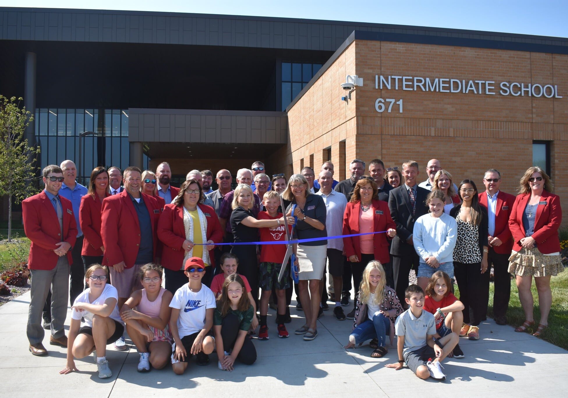 ribbon cutting intermediate school with a group of teacher and kids